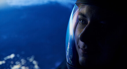 Close up view of woman in glassed space helmet against blue background