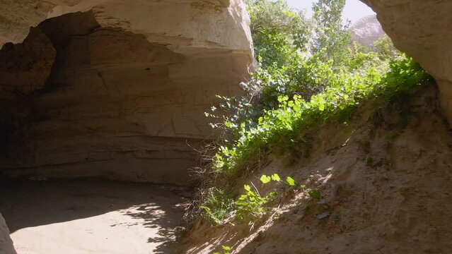 Embark on a visual journey with this mesmerizing aerial stock video capturing the essence of Cappadocia in Turkey. The drone flies through a tunnel carved in a rock by a flowing water.