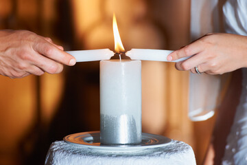 Couple, hands and candle at wedding for unity, love and commitment at church or ceremony with...