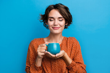 Photo portrait of lovely young lady smell aroma coffee house wear trendy brown garment isolated on blue color background - obrazy, fototapety, plakaty