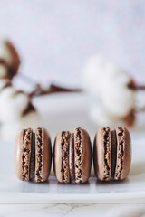 Trois macarons parfum chocolat avec un fond clair