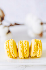 Trois macarons parfum citron avec un fond clair
