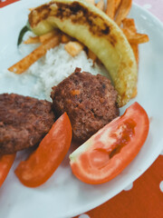 Turkish lunch, meat cutlets, rice and grilled vegetables, soft focus.