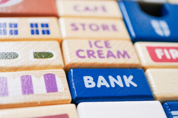 The wooden building blocks are painted colorful and focus on the words bank