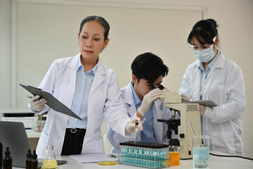 A group of researchers of various ages are conducting an experiment in a lab