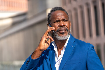 Mature african businessman talking to the phone outdoors