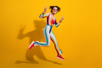 Fototapeta na wymiar Photo of youth lady jumping enjoy night club fun make v sign isolated shine color background