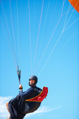 Man, portrait and paragliding in blue sky parachute for adventure fun, clouds or explore city. Male...