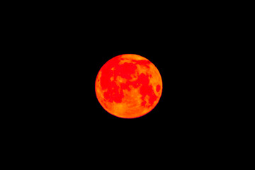 Bright orange red light nature moon object in the night sky, close-up