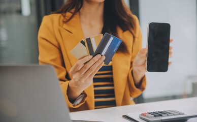 Women holding credit card and using smartphones at home.Online shopping, internet banking, store...