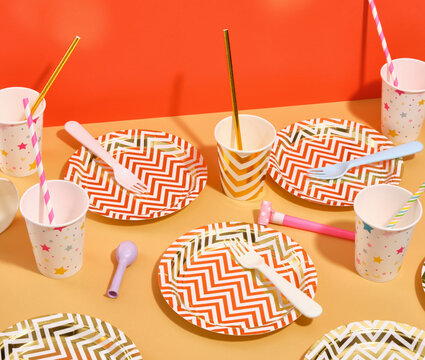 Festive table setting for a holiday party. Colorful plates, forks and cups.