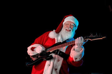 Santa Claus playing the electric guitar in a nightclub at a Christmas and New Year party or...