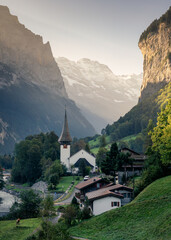 Fototapeta na wymiar View of Lauterbrunnen valley with rustic village, famous church and Staubbach falls during end of summer at Switzerland