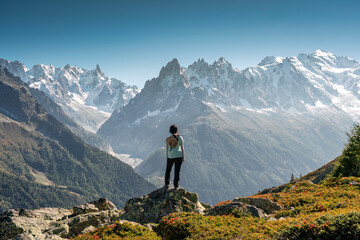 A female hiker standing with enjoying the Mont Blanc mountain range view during trail in Lac Blanc at France - obrazy, fototapety, plakaty
