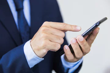 Foto op Plexiglas スマホを操作するビジネスマン businessman touching smartphone © kyo