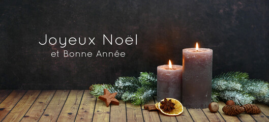 Carte de Noël : décoration de Noël romantique avec deux bougies allumées et des branches de...