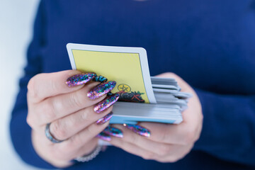 Female hands holding tarot cards for fortune telling and tricks