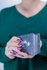 Female hands holding tarot cards for fortune telling and tricks