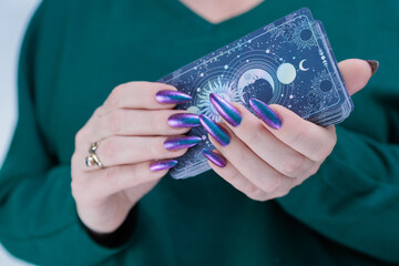 Female hands holding tarot cards for fortune telling and tricks