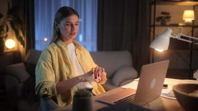Beautiful young blonde woman having video call conference meeting interview by laptop computer at home Confident female talking on working conversation having distance remote job at night indoors