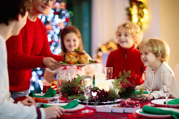 Christmas dinner. Family with kids at Xmas tree. - obrazy, fototapety, plakaty