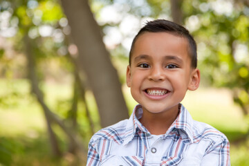 Smiling Young Hispanic Boy Outdoors Amongst the Trees. © Andy Dean