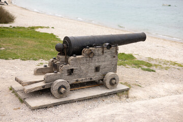 Fototapeta na wymiar Old cannon on beach front.