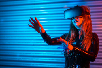 Amazed futuristic woman using Virtual reality goggles