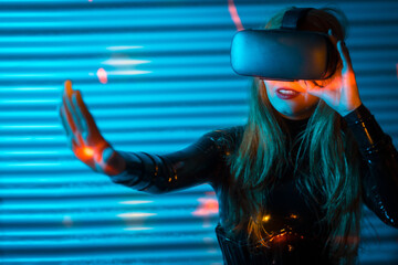 Blonde woman playing using virtual reality goggles