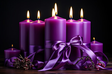 Obraz na płótnie Canvas Burning purple candles with ribbons on wooden table, closeup