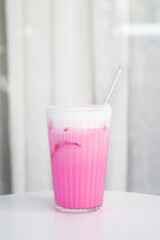 a glass of ice sweet pink milk Thai Nom Yen or Thai milk on white table