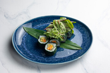 Japanese cuisine. Vegan rolls with avocado, herbs and carrots.