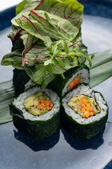 Japanese cuisine. Vegan rolls with avocado, herbs and carrots.