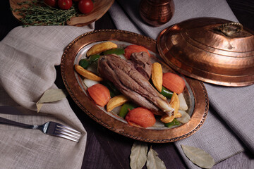 Traditional BBQ leg of lamb with vegetables and chilli served on a rustic metal tray, top view. High quality photo