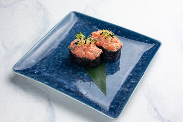 Japanese cuisine. Gunkan on blue plates
