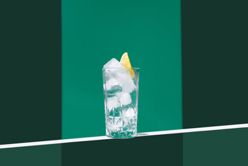 Refreshing gin tonic drink on a minimalistic green background