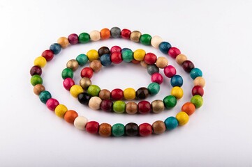Multicolored wooden beads on a white background.