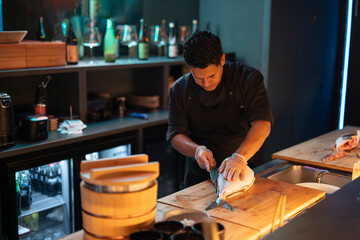 Sushi chef expertly preparing food at a restaurant