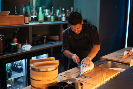 Sushi chef expertly preparing food at a restaurant