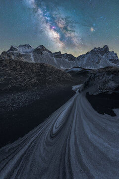 Galactic Arc over Snowy Dune Trails at Night