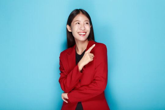 Portrait of a beautiful young woman in a light blue background, Standing and pointing happily, happy and smile, posting in stand position.