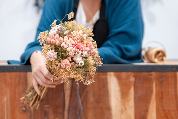 Anonymous florist holding beautiful dried flower bouquet