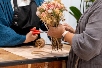 Anonymous florist selling bouquet to customer in flower shop