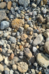 A pile of rocks sitting on top of each other. The rocks are of various sizes and shapes, and they are arranged in a haphazard manner. There is a small ant crawling on one of the rocks