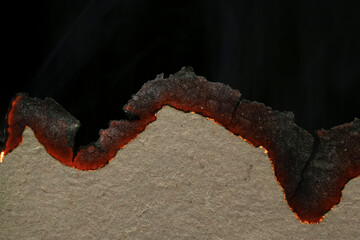 burning paper, glowing edge of paper on a black background