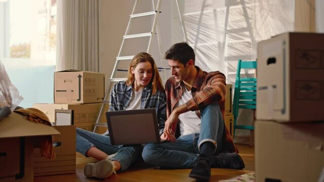 A young couple of beautiful and happy guys who have just bought a house and use the computer to furnish it.
Concept of: dreams, architecture and design