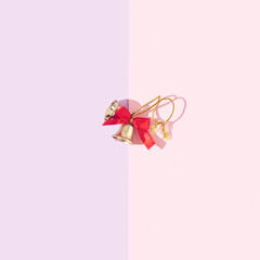 Beautiful golden jingle bells with a red bow. Minimal holiday concept. Copy space for text. Flat...