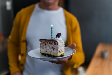 Pieces of cake on a plate in focus, chocolate oreo cake with a candle in the middle