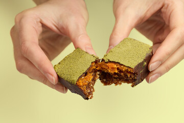 Woman's hands breaking vegan chocolate bar with dried fruits