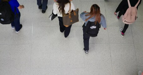 City life of a person busy with daily routine is revealed. People are moving along the street in one direction, each going about their daily business. Top view shows movement of people in city.